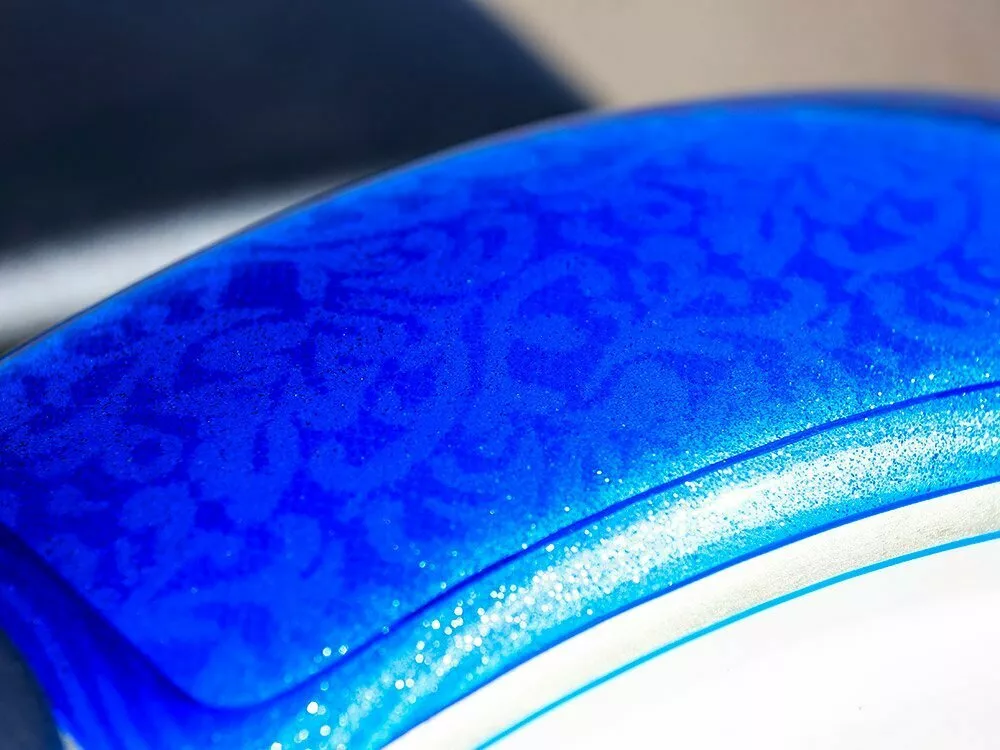 white gold leaf designs on blue motorcycle body