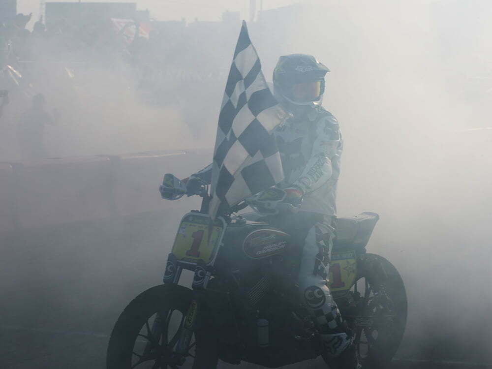 Andy DiBrino holding the checkered flag 