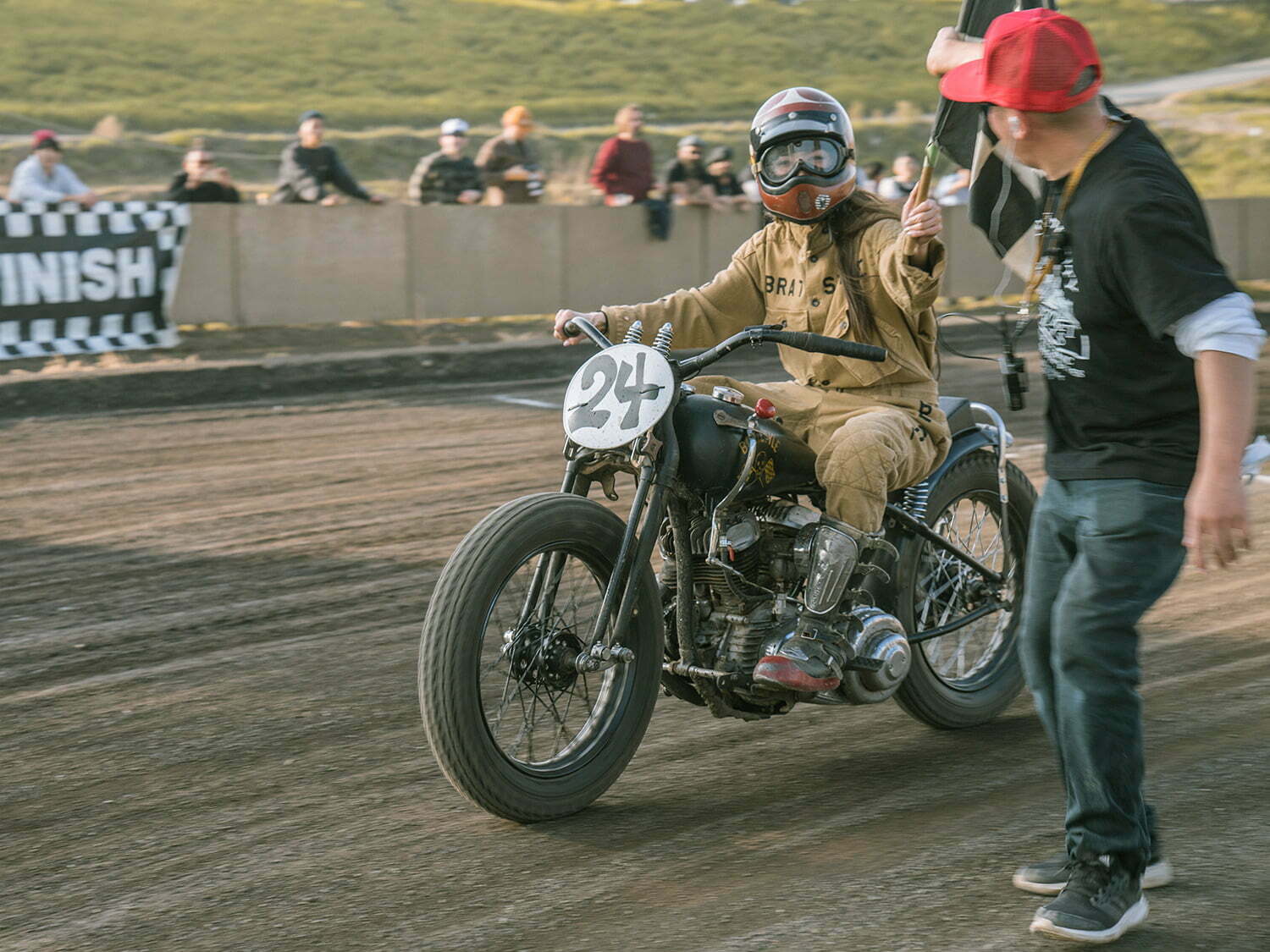 motorcycle rider in bratstyle gear grabbing checkered flag
