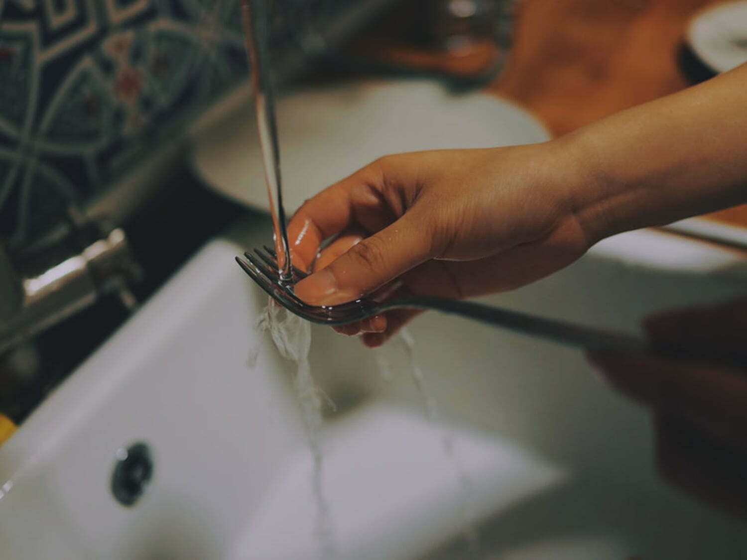 female hand washing a fork