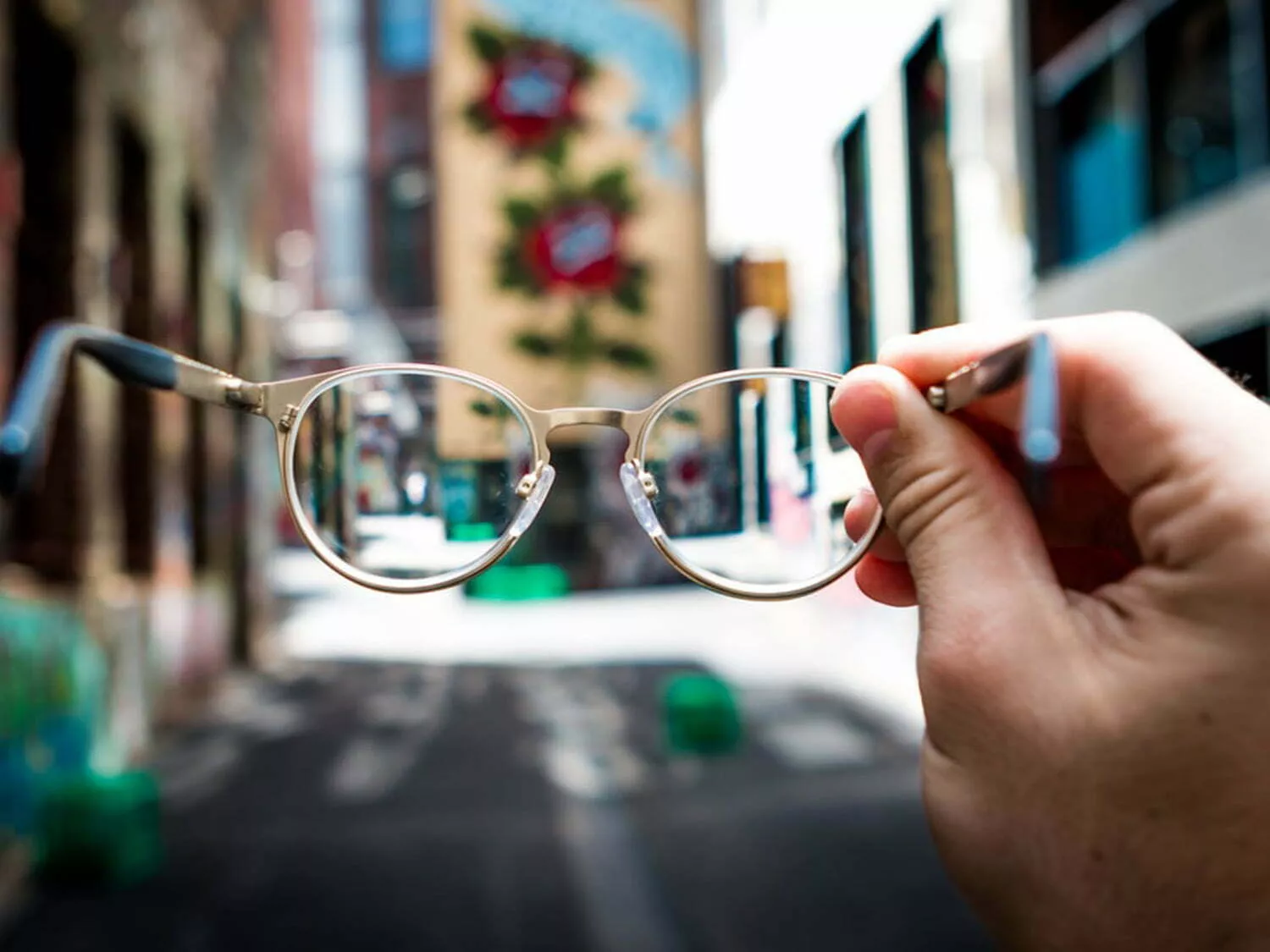 Person holding a pair of glasses.