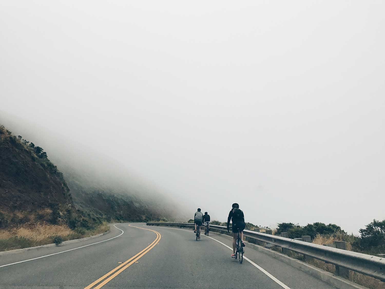 Riding bikes through foggy mountains.