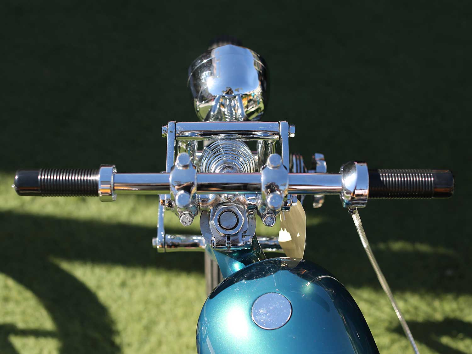 A clean and polished handlebar and front end setup on this skinny Panhead chopper.