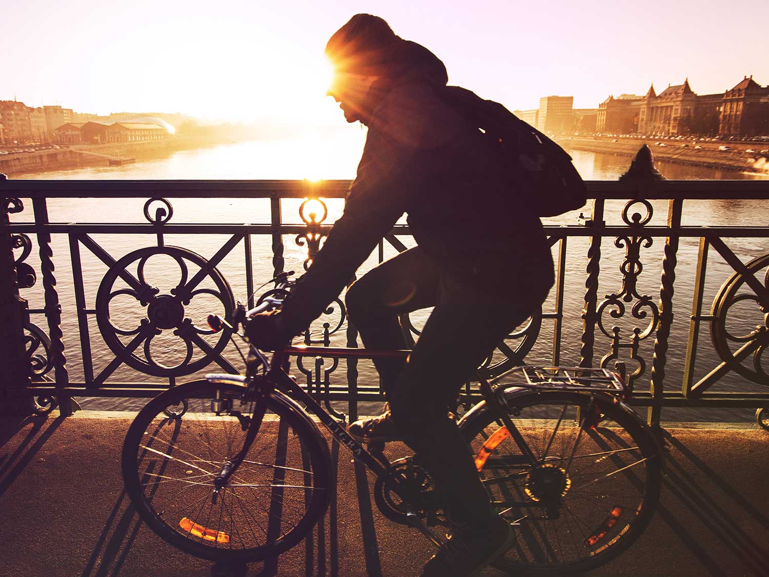 Cycling across a bridge wearing gloves and warm gear.