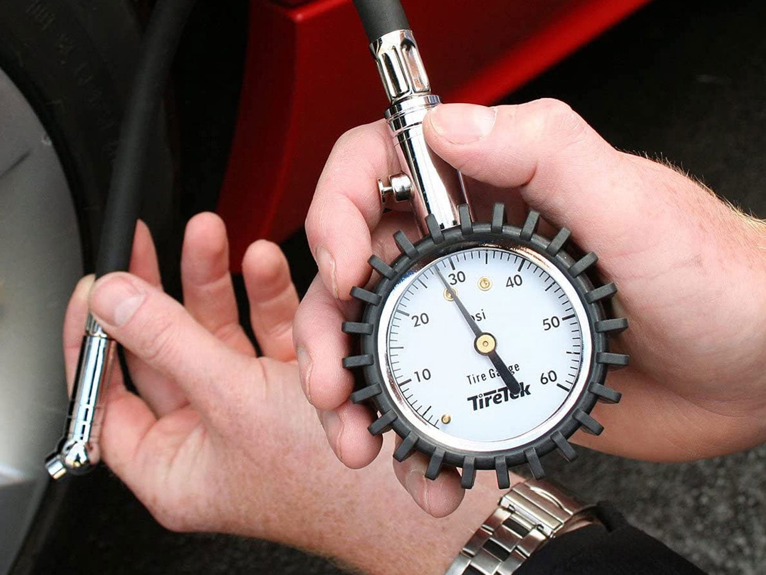 Checking tire pressure with a motorcycle tire-pressure gauge