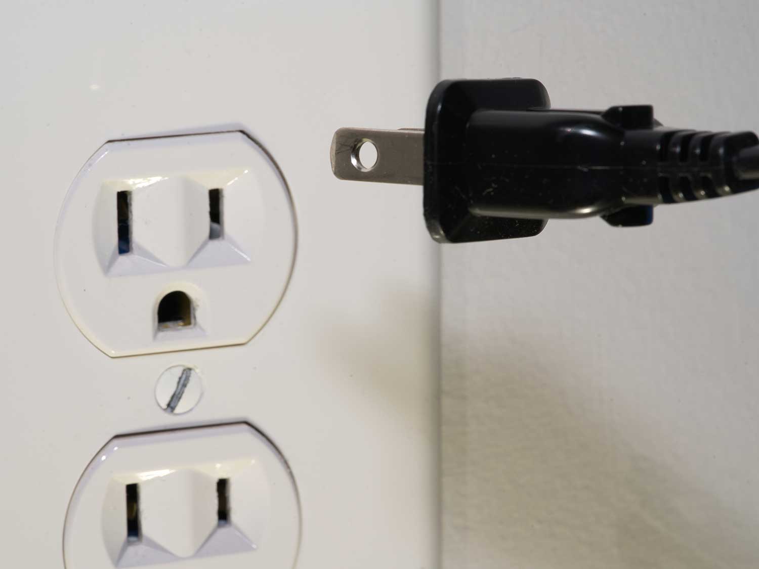 Plugging electrical cord into power outlet.