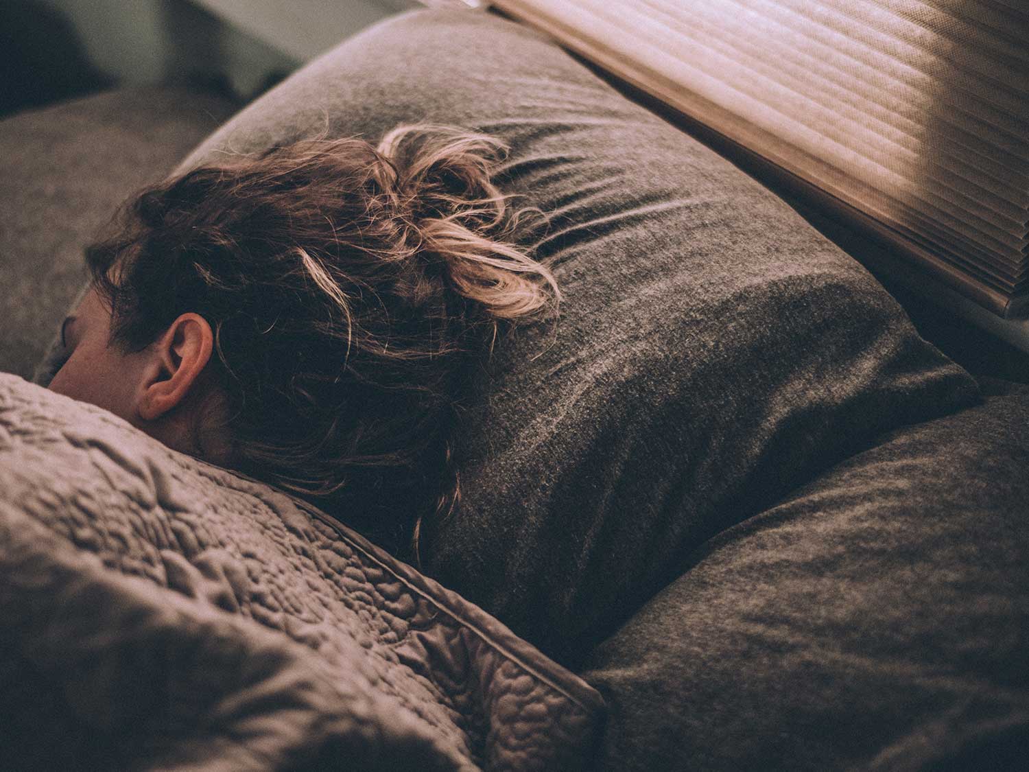 Woman sleeping peacefully under the covers.