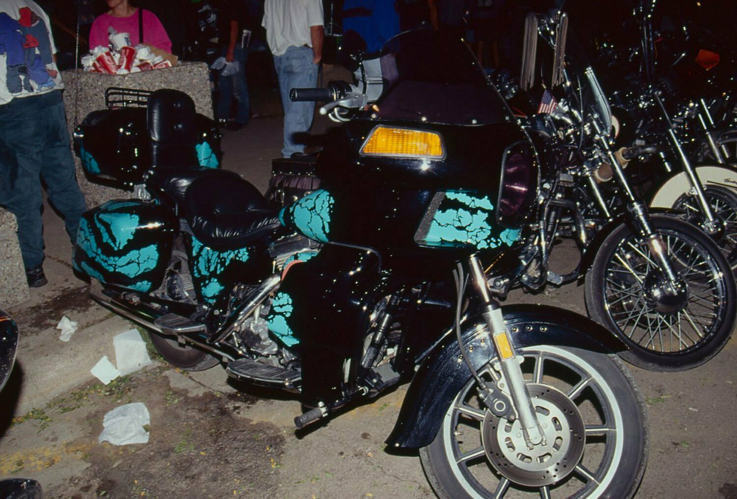 Even in poor lighting this Harley’s marbled cyan paint stands out from the other parked hogs.