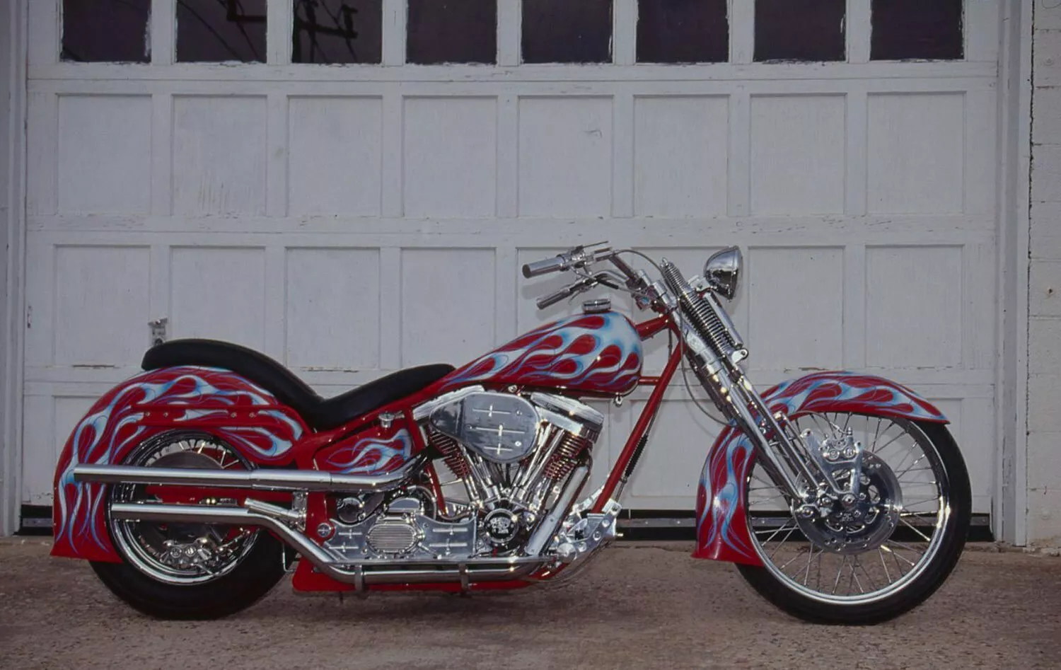 Ed Kerr’s 1990 Softail Springer pops with Porsche Red, white blue flames, and pinstriping.