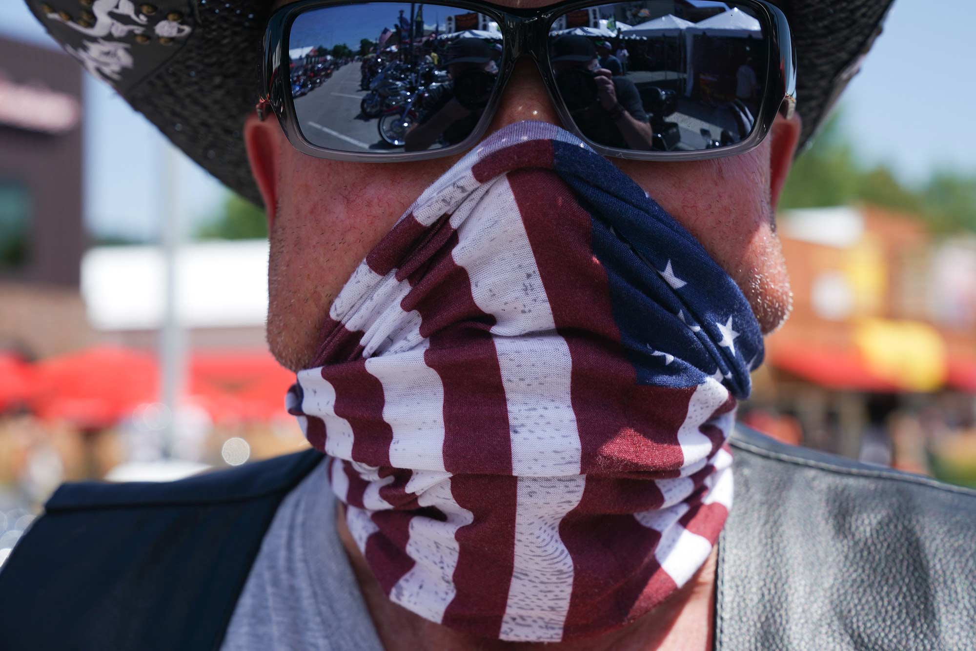 Sturgis rally participant Dane Senser wears an American flag face covering as he poses on Main Street.