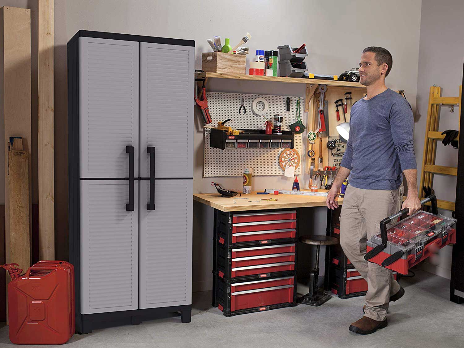 Man walking with toolbox in garage with garage storage.