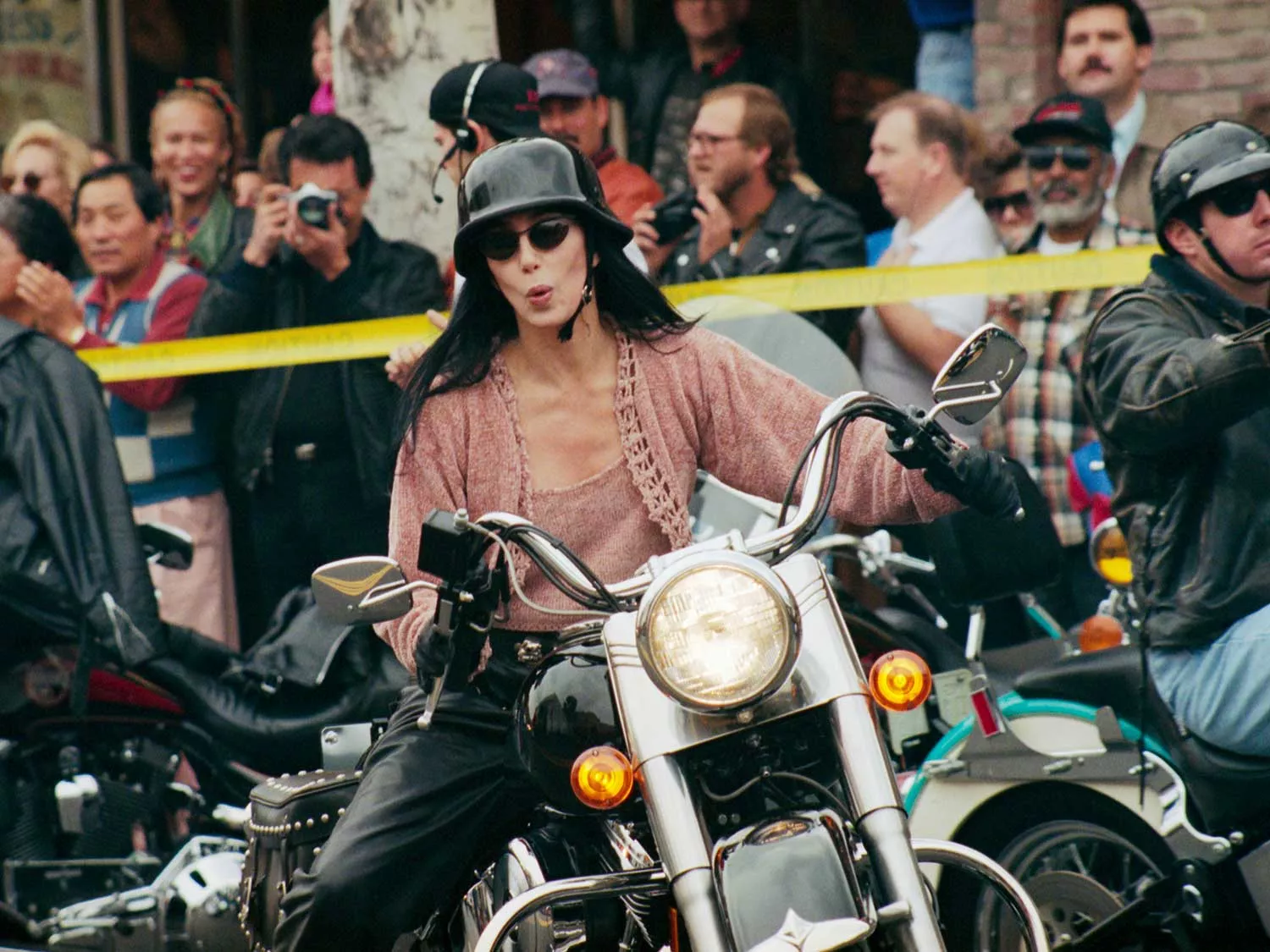 Cher rides a Harley-Davidson in 1994 at a Christmas parade on Rodeo Drive.