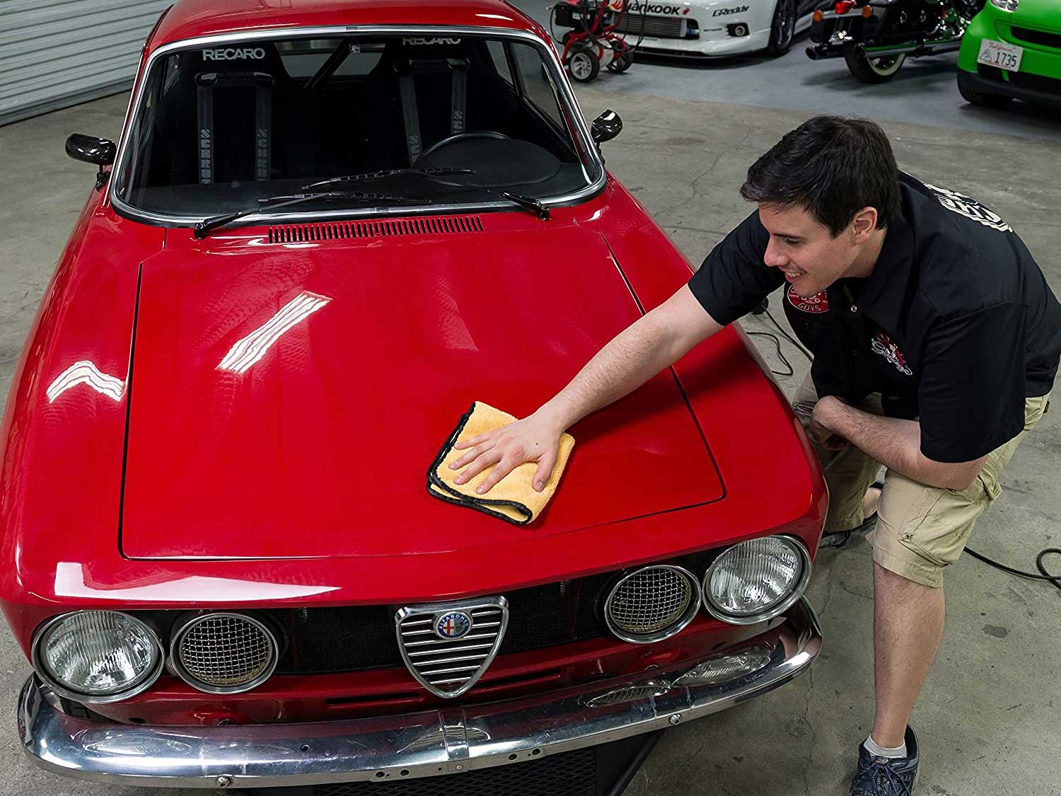 Man cleaning car with microfiber cloth.