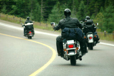 Three guys riding motorcycle on the highway.